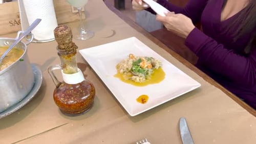 Arrangement of seafood with rice in a restaurant. A woman is preparing to eat delicacies on a holida