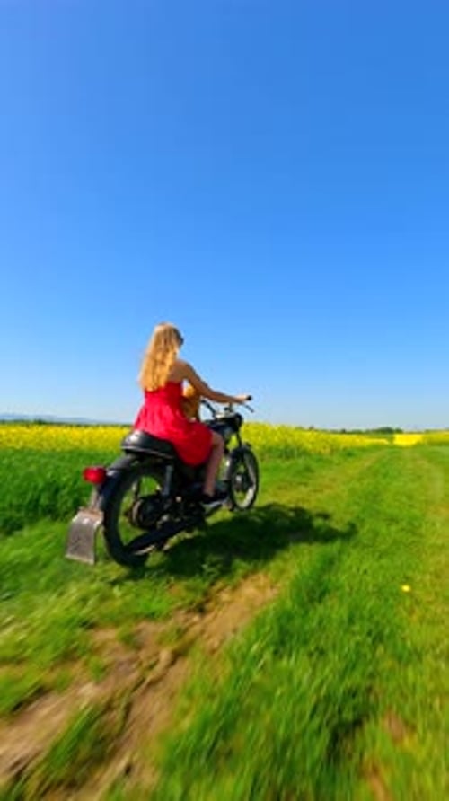 FPV of Woman and Dog Riding a Vintage Motorcycle in the Countryside