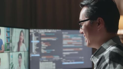 Gros plan d'un programmeur agitant la main lors d'une réunion sur un ordinateur de bureau tout en créant un logiciel