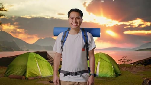 Asian Male Smiling To Camera While Tent Camp Lakeside