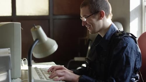 Young Man Typing on Computer Keyboard in Office