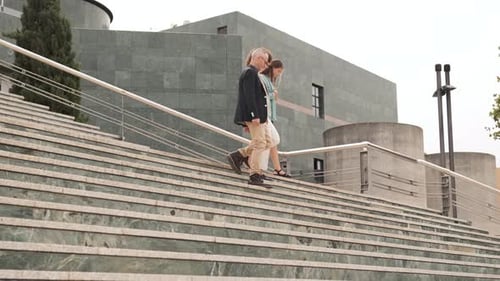 Happy Business People Talking While Descending Stairs in City