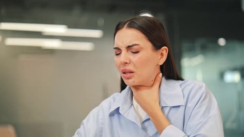 Unwell Woman With Sore Throat And Coughing In Office