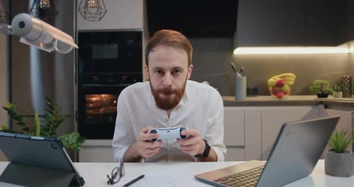 Man Playing Video Game at Kitchen Table