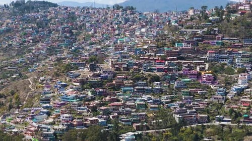 Aerial drone shot of a tightly packed city in the mountains, Population control