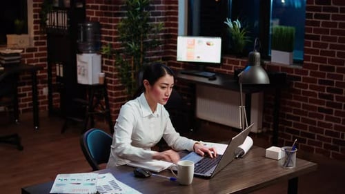 Woman Excited About Project Success in Office at Night