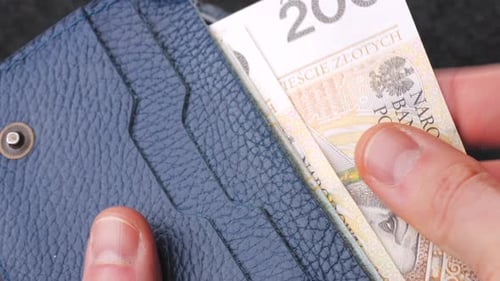 A Closeup View of Cash Being Stored in a Blue Wallet for Financial Purposes