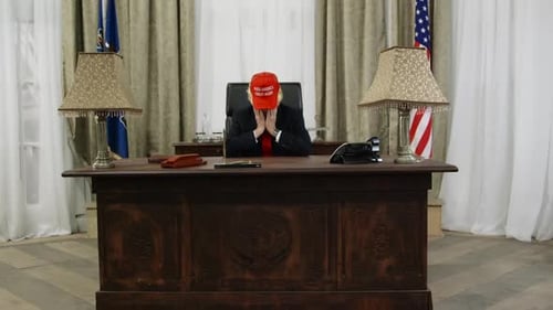 Man in Suit With Head in Hands in Office