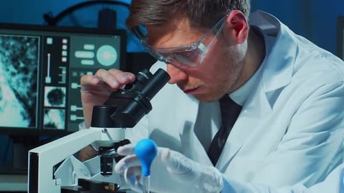 Man Uses Microscope in Laboratory for Scientific Research