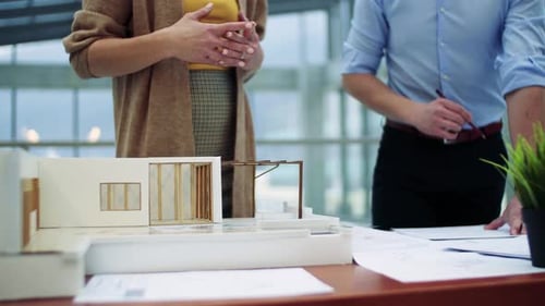 Architects collaborate on house model design in bright modern office space