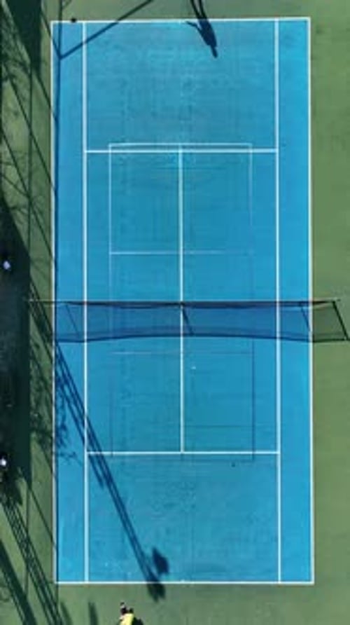 Vertical Video Aerial View of PalmEncircled Tennis Court Thrilling Match