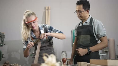 Carpenters are working together at workshop.