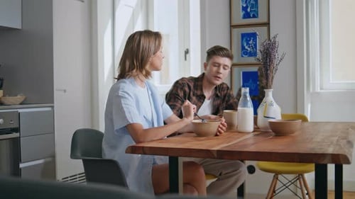 Young Couple Eating Breakfast Together in Cozy Kitchen