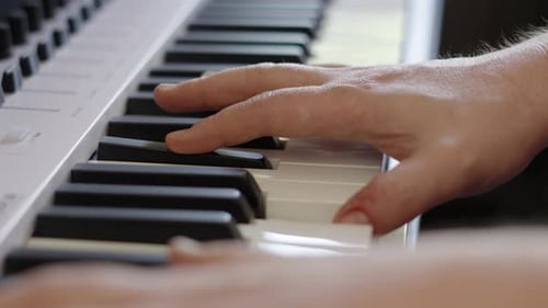 Compositor masculino tocando elegantemente las teclas del piano en diferentes acordes para una sesión de grabación