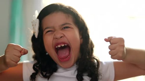 Funny upset little girl yelling at camera. Angry child screaming