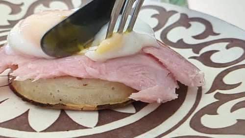 Poached Eggs with Ham and Crumpet Opened and Running Over Plate