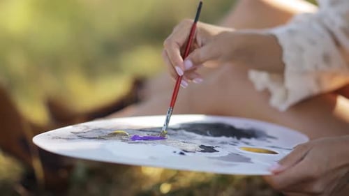 A Talented Artist Paints a Picture on a Canvas in a Beautiful Autumn Forest Using Brushes and Paints