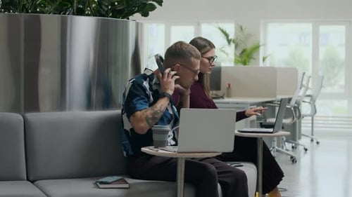 Collègues travaillant sur un ordinateur portable dans un espace de travail contemporain