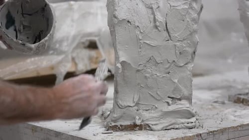 Formenbauer verwendet Werkzeug und flüssigen Putz, um in der Werkstatt Formen zu bauen.