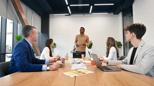 Black male team leader at business meeting in an office, discussing business affairs with other work