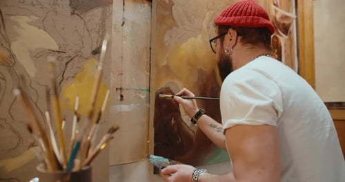 Male Artist Paints a Canvas in His Art Studio