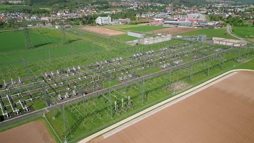 Transformers at modern electrical distribution substation with cables and pylons