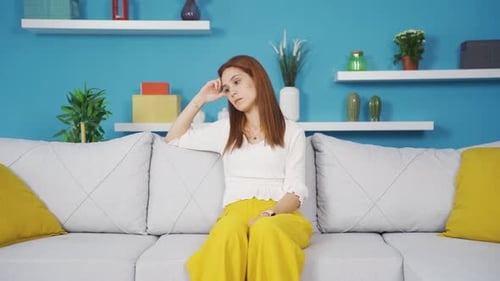 Thoughtful Woman Sitting on Sofa at Home