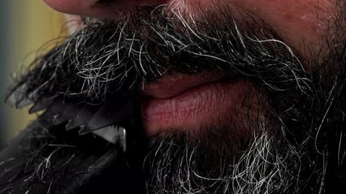 Close up of beard being trimmed by razor