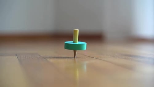 Delightful Spinning Top Spins on Wood Floor