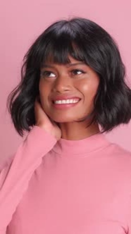 Smiling Woman Posing in Front of Pink Background