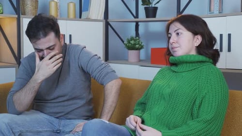 Upset Man and Woman Sitting Apart on Couch