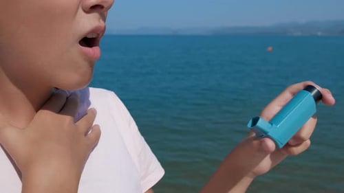 Person Uses Inhaler at the Beach on Sunny Day