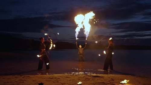 Enigmatic Fire Show On River Coast In Night People Spinning Burning Torches In Darkness