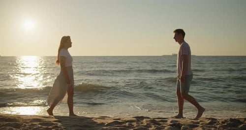 Young Loving Couple Enjoying Relaxing Sunset Walk on the Beach