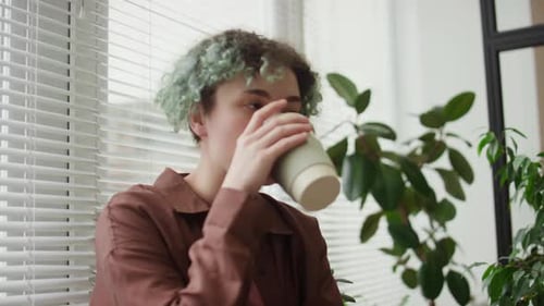 Girl with Prosthetic Arm Drinking Coffee and Speaking to Colleague