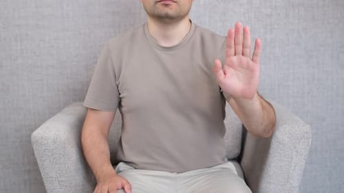 Person Sits and Gestures Stop Hand