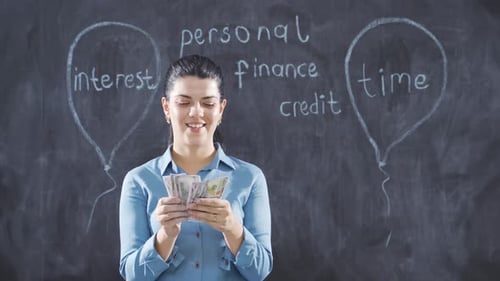 The woman who writes Consumer Loans on the blackboard looks with a happy expression.