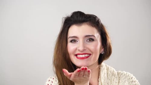 Woman Blowing Kiss with Red Lipstick and Wavy Hair