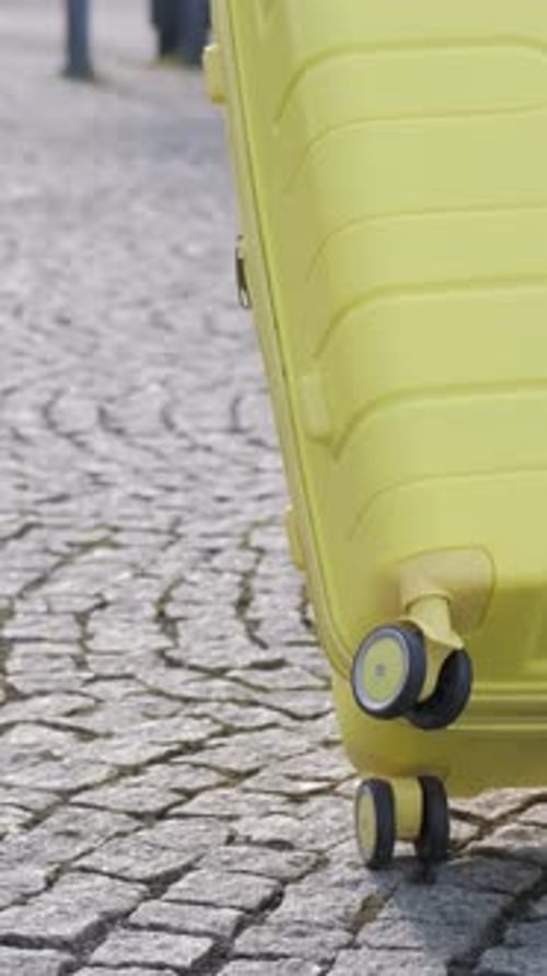Slow Motion of a Female Tourist Walking Down the Street and Carrying a Suitcase Vertical Video