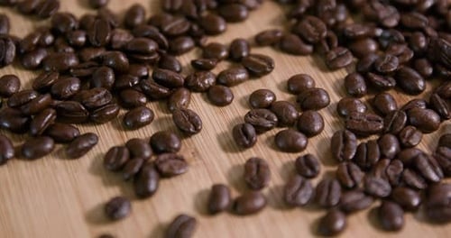 Close Up Of Roasted Coffee Beans on Wooden Surface