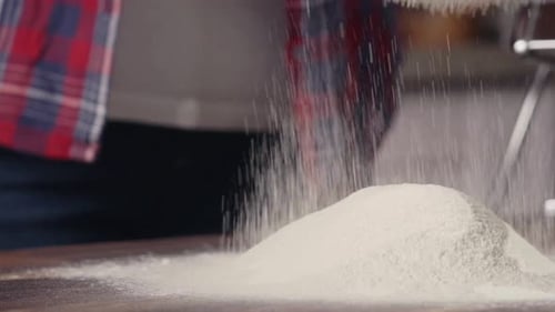 Sifting Flour for Baking on a Wooden Table