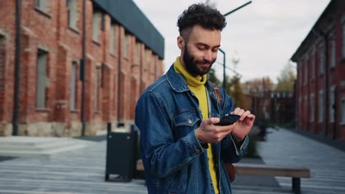 Young Adult Using Phone in Urban Setting