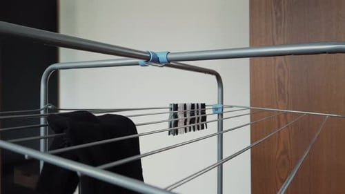 Placing Black Clothes on a Metal Drying Rack