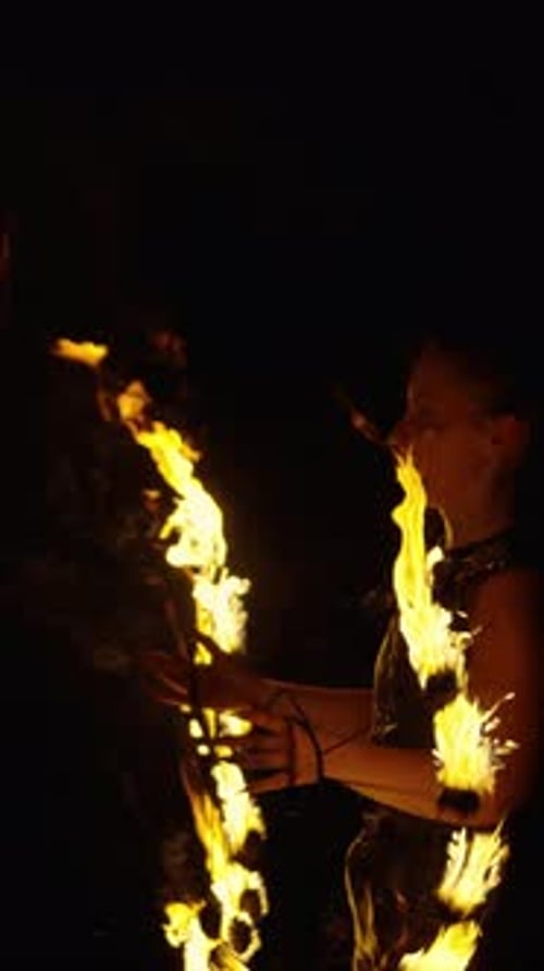 Dynamic Fire Dance Performance with Spinning Flames and Expressive Movement Captured Against a Dark