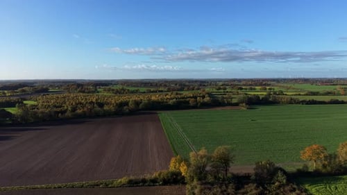 Picturesque farmland fields of America during sunny day in fall season. Aerial wide shot.