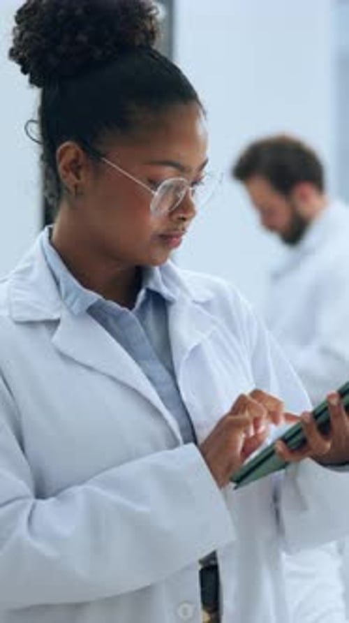 Woman Using Tablet in Lab with Bearded Man