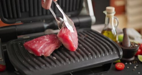 Two Pieces of Tuna Steak Grilling Frying on Electric Grill at Domestic Kitchen