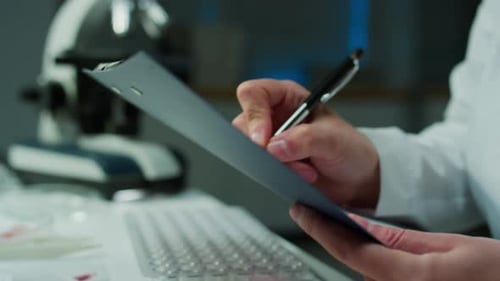 Hands of Forensic Scientist Taking Notes on Paper in Crime Lab
