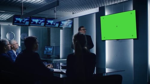 Business meeting with presenter and green screen display