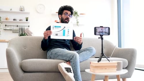 Man Teaching Financial Literacy Via Video on Smartphone